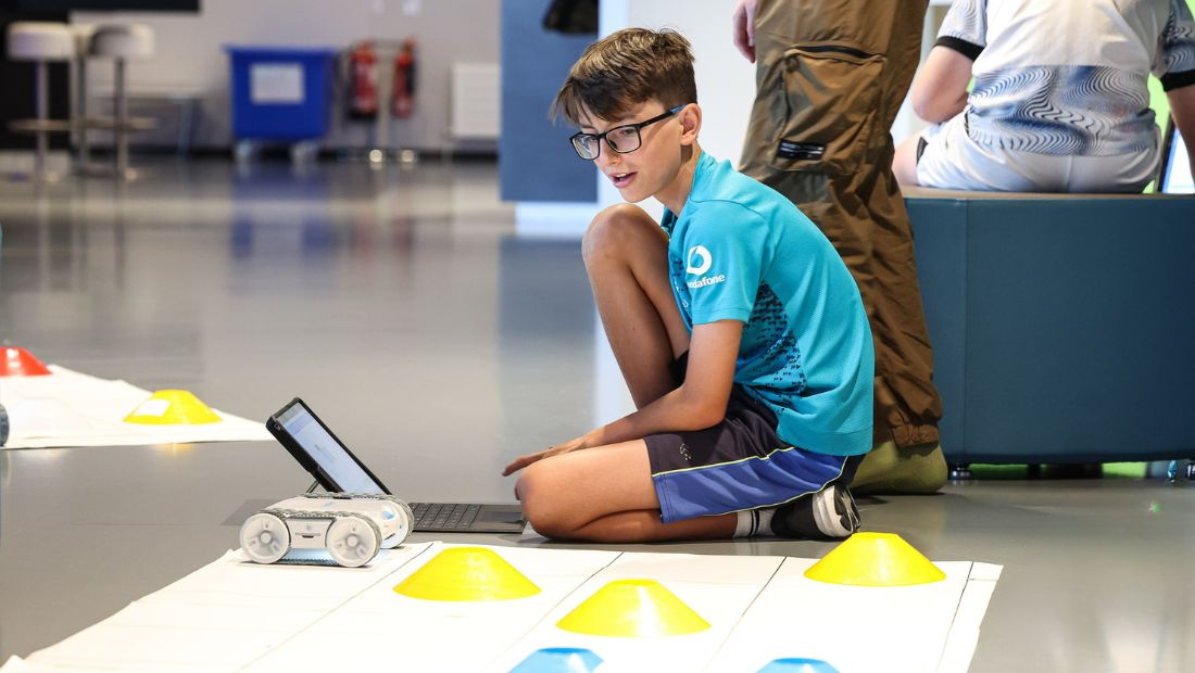 Young participant using a robot during a W5 LIFE robotics workshop